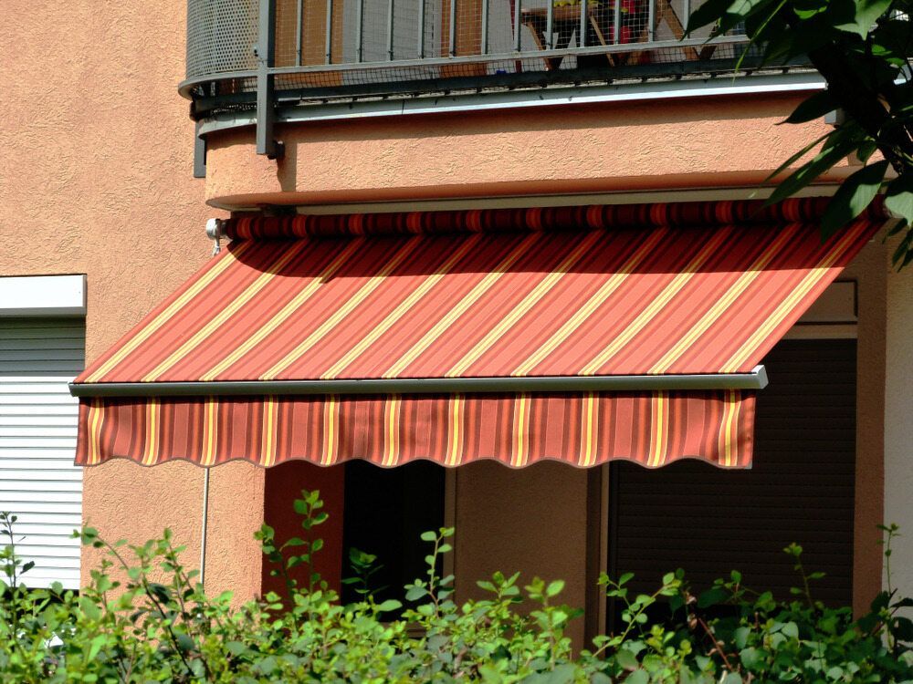 A Red and Yellow Striped Awning on a Balcony — Off Shore Sails & Rigging In North Boambee Valley, NSW