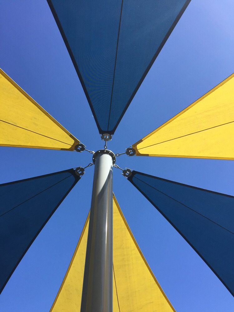 Looking Up at a Blue and Yellow Sail Shade Against a Blue Sky — Off Shore Sails & Rigging In North Boambee Valley, NSW