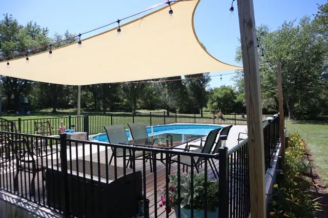 A patio with a swimming pool and a canopy over it