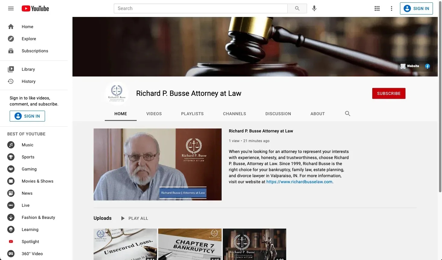 A man with a beard is sitting in front of a judge 's gavel on a youtube channel.