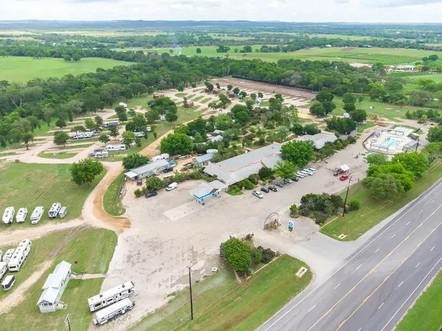 An aerial view of a campground surrounded by trees and a road.