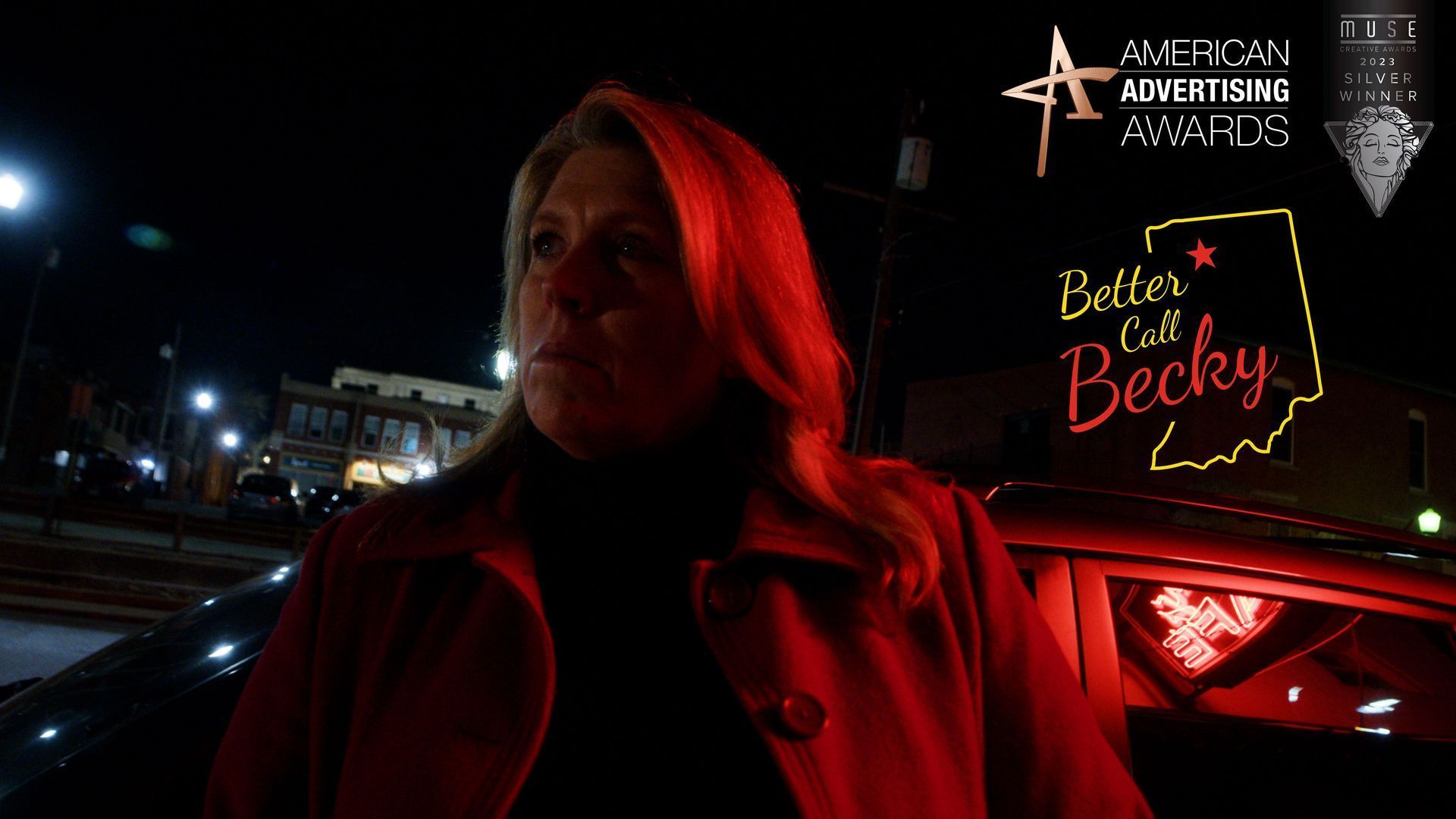 A woman in a red coat is standing in front of a sign that says better at becky