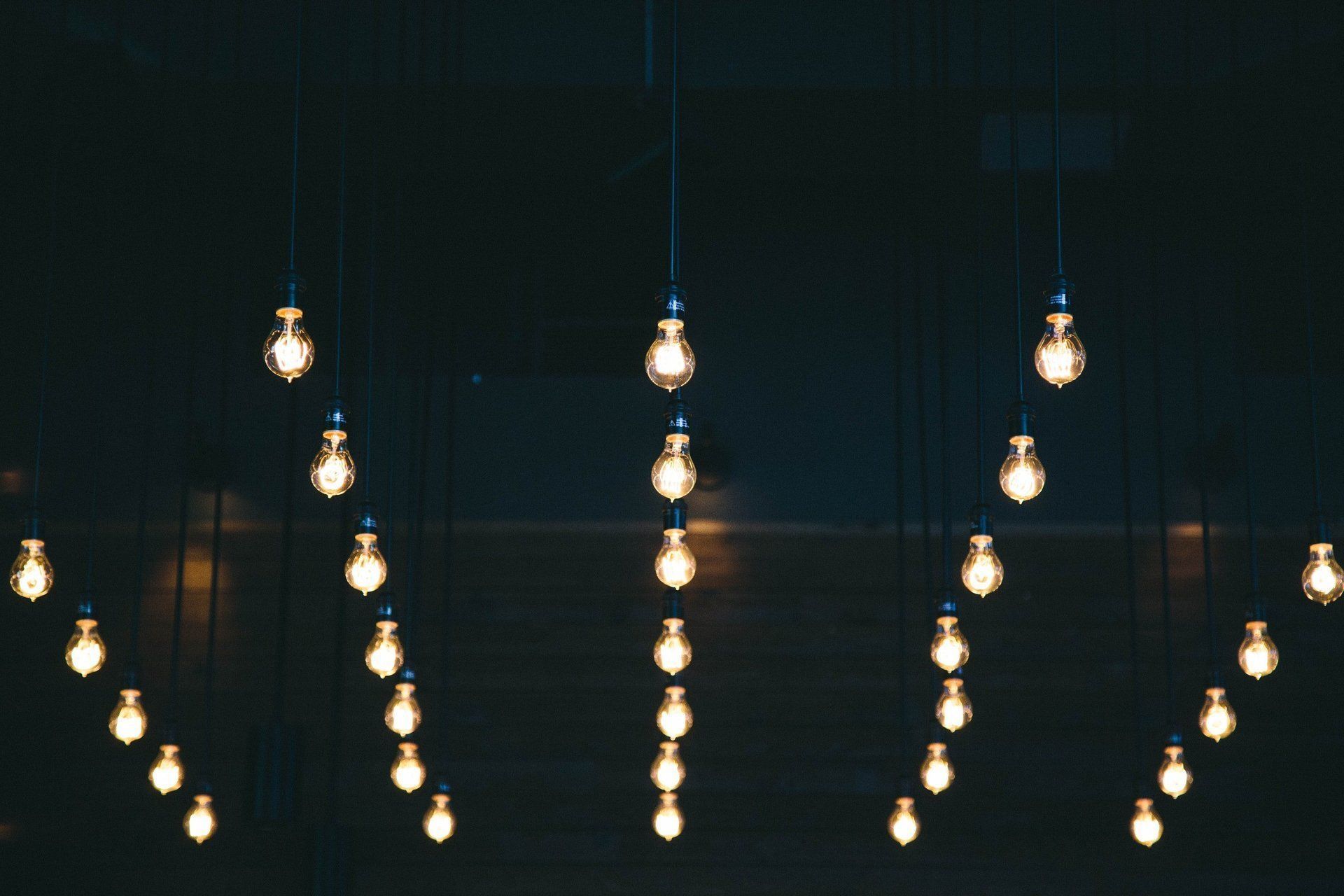 A string of light bulbs hanging from the ceiling in a dark room.