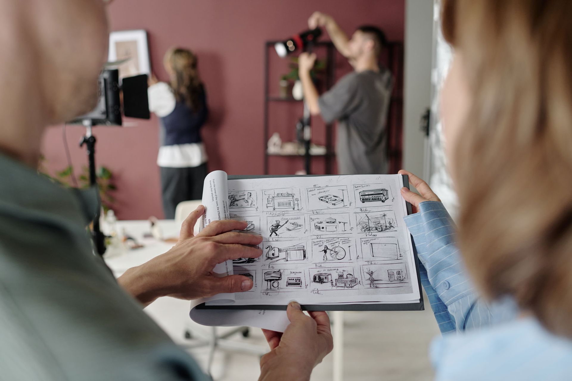 A man and a woman are looking at a drawing in a book.