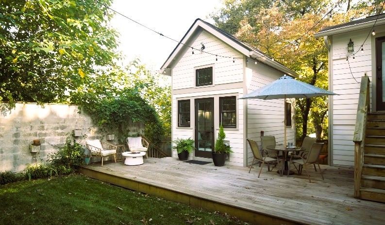 Cozy backyard guest house with deck, shed, and string lights