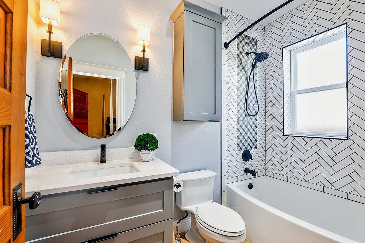 Modern bathroom with vanity, tile shower, and lighting