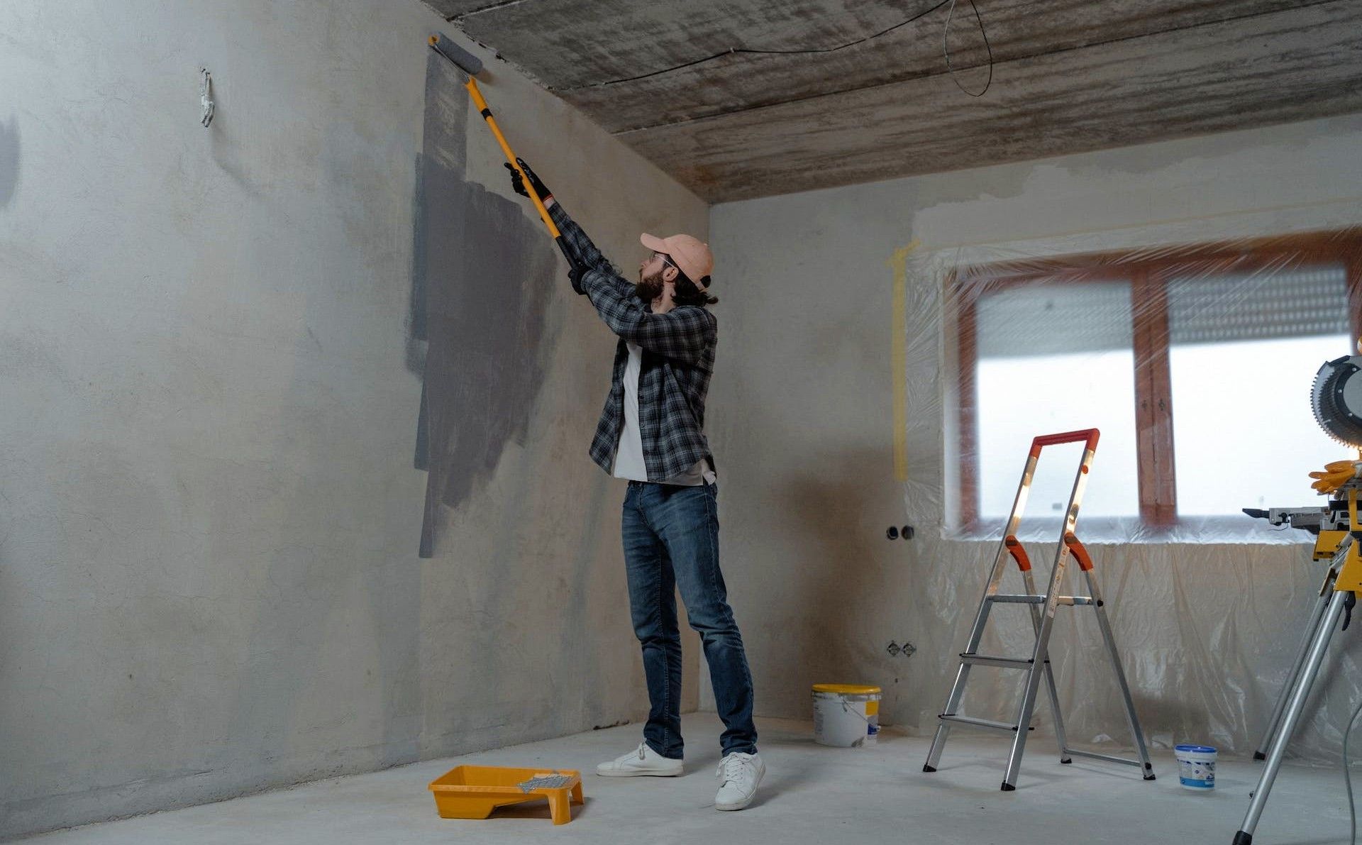 A homeowner painting a wall during home renovation