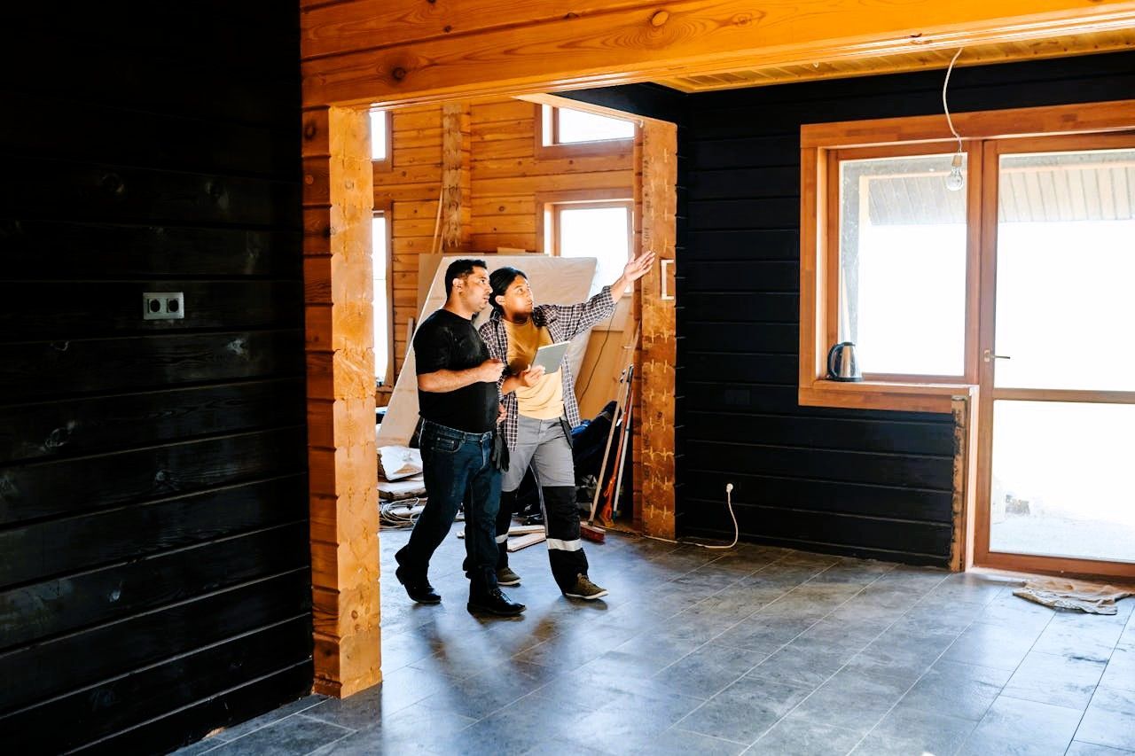 Two people discussing plans in a home under construction