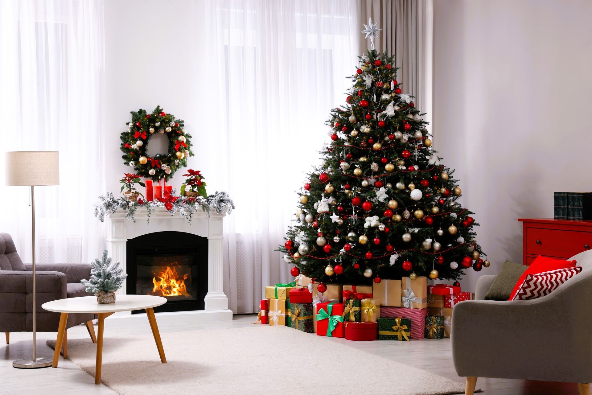 Beautiful Christmas tree and gifts near fireplace in festively decorated living room