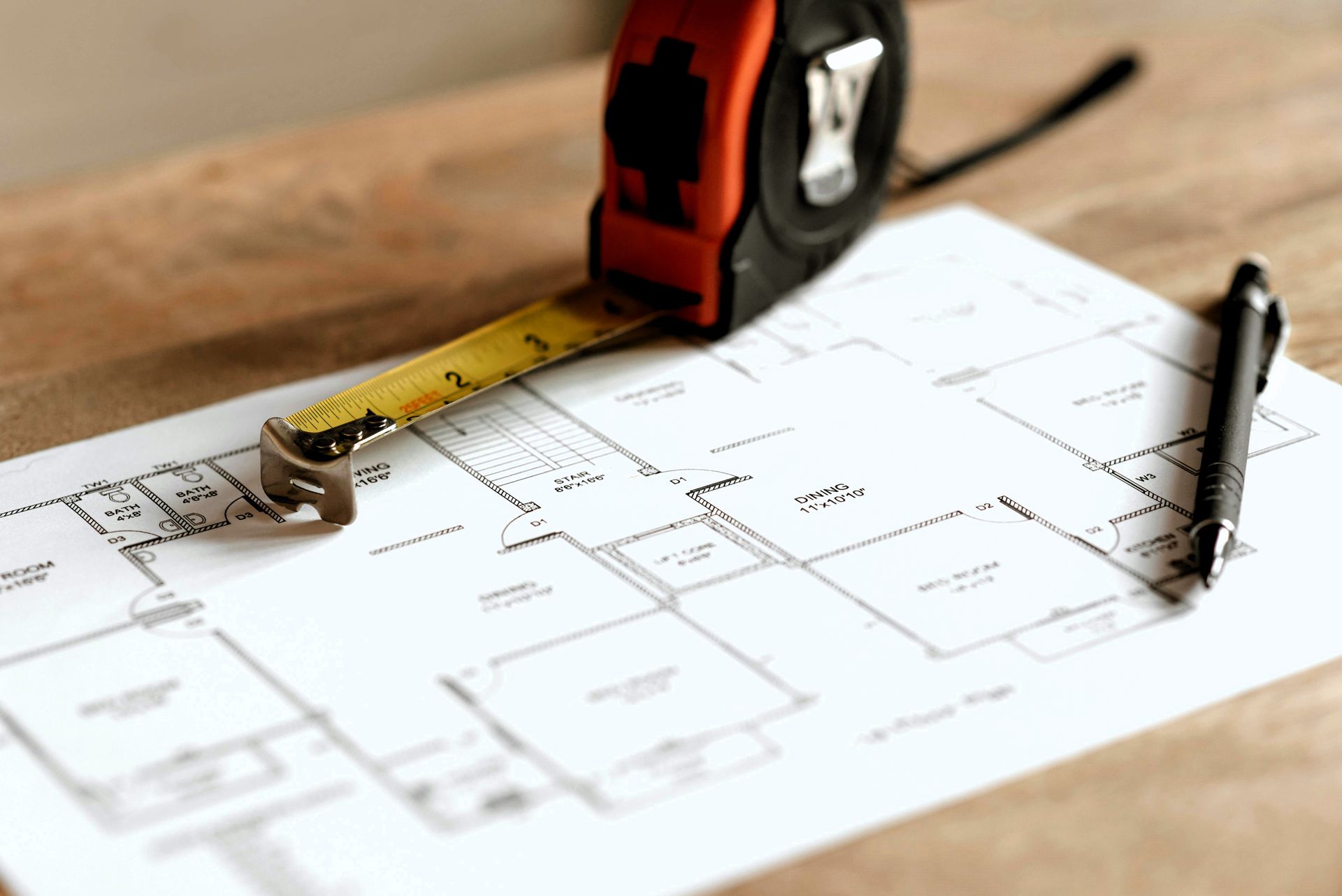 Tape measure and pen on architectural blueprint.