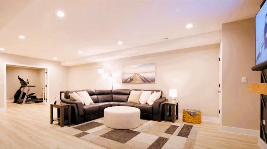 Modern budget-friendly rec room renovation with sectional sofa, cozy lighting, and stylish flooring