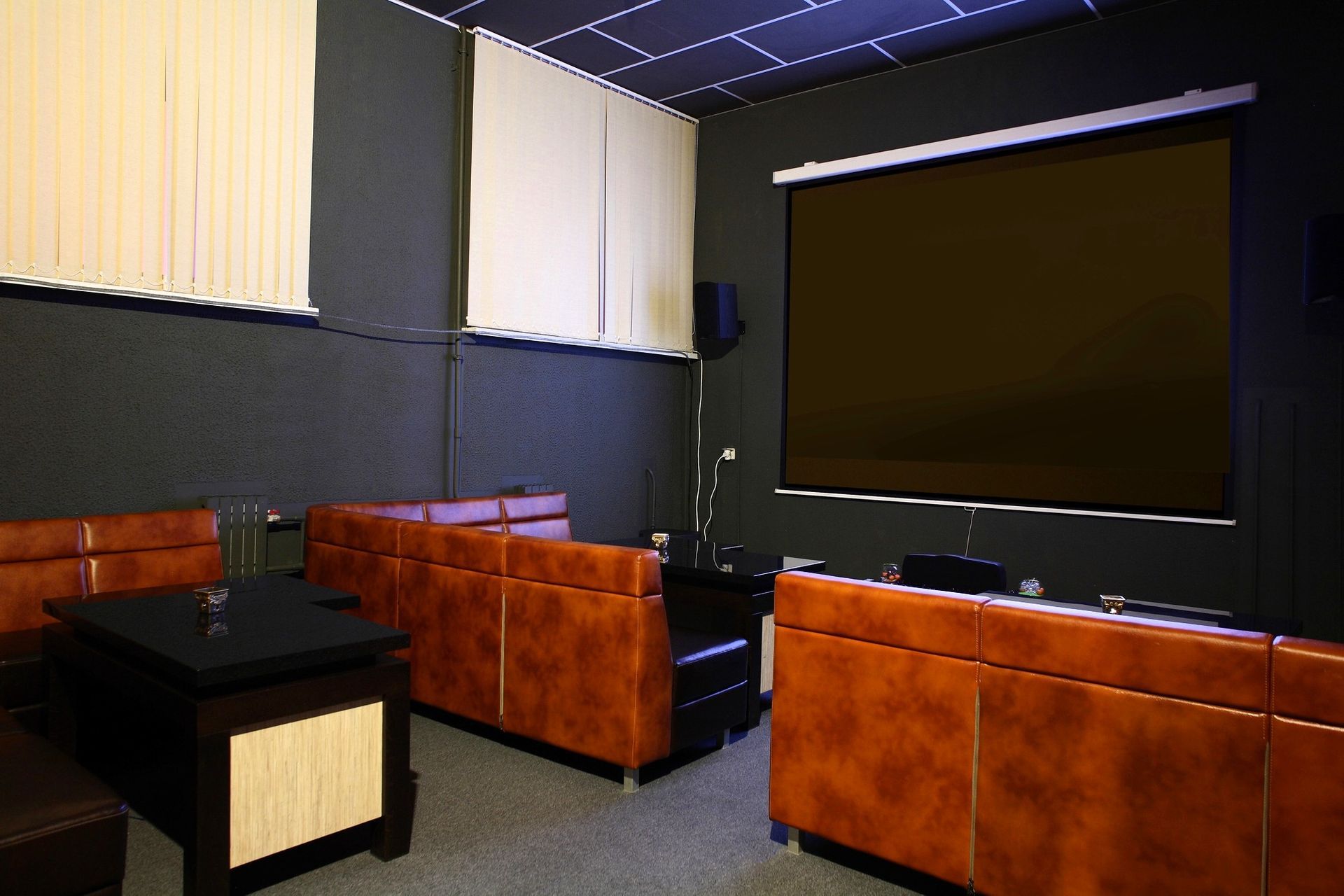 Soundproof home theater with orange leather couches and a large projection screen