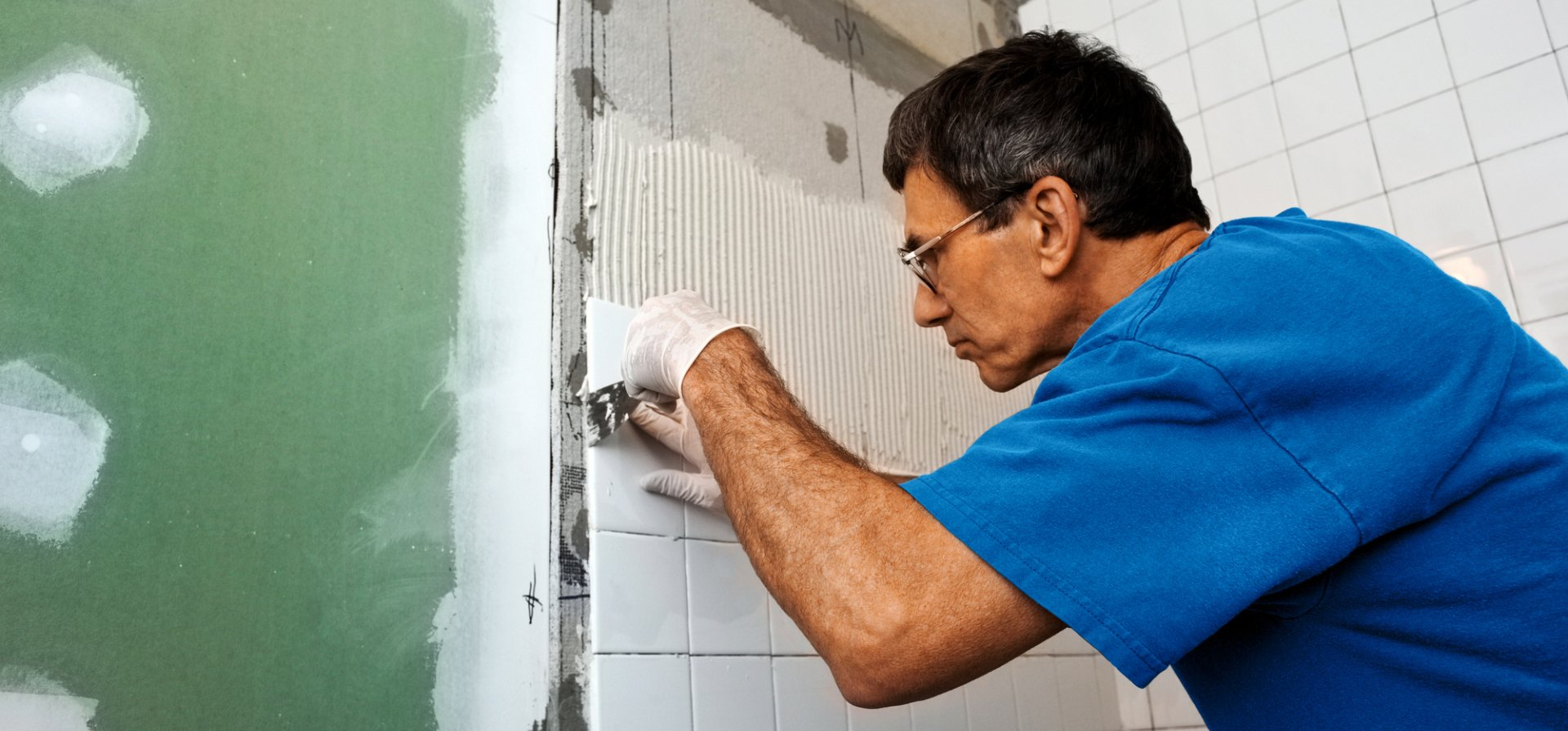 a man doing the tiles of the bathroom