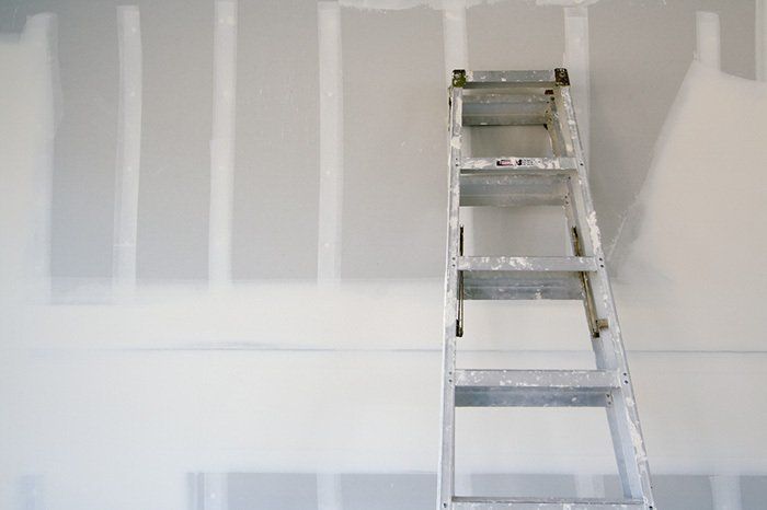 aluminum ladder resting again unfinished drywall on home renovation job site