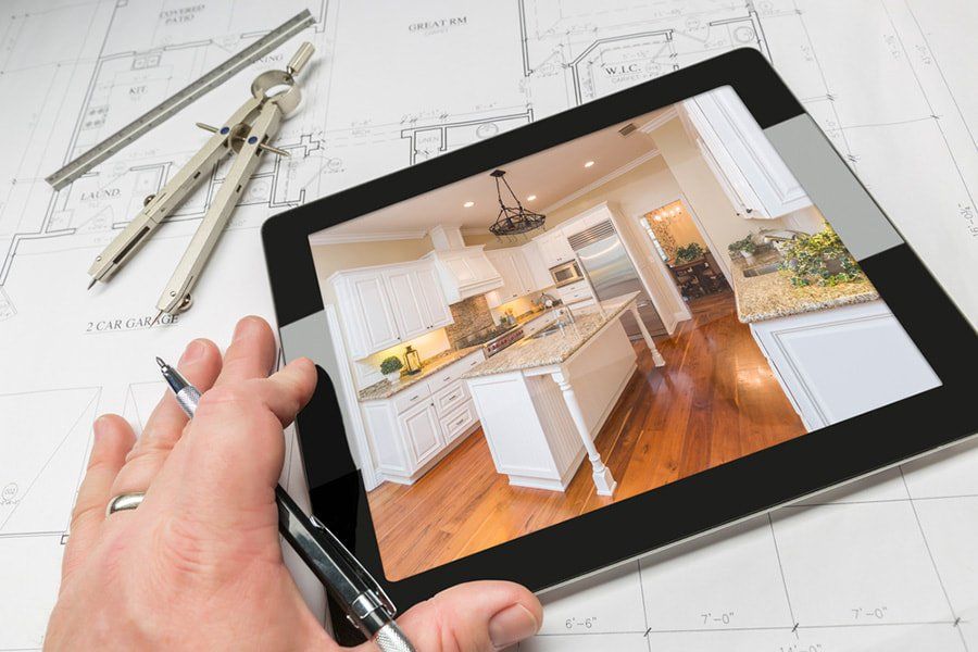 designing a kitchen remodel on tablet with paper plans