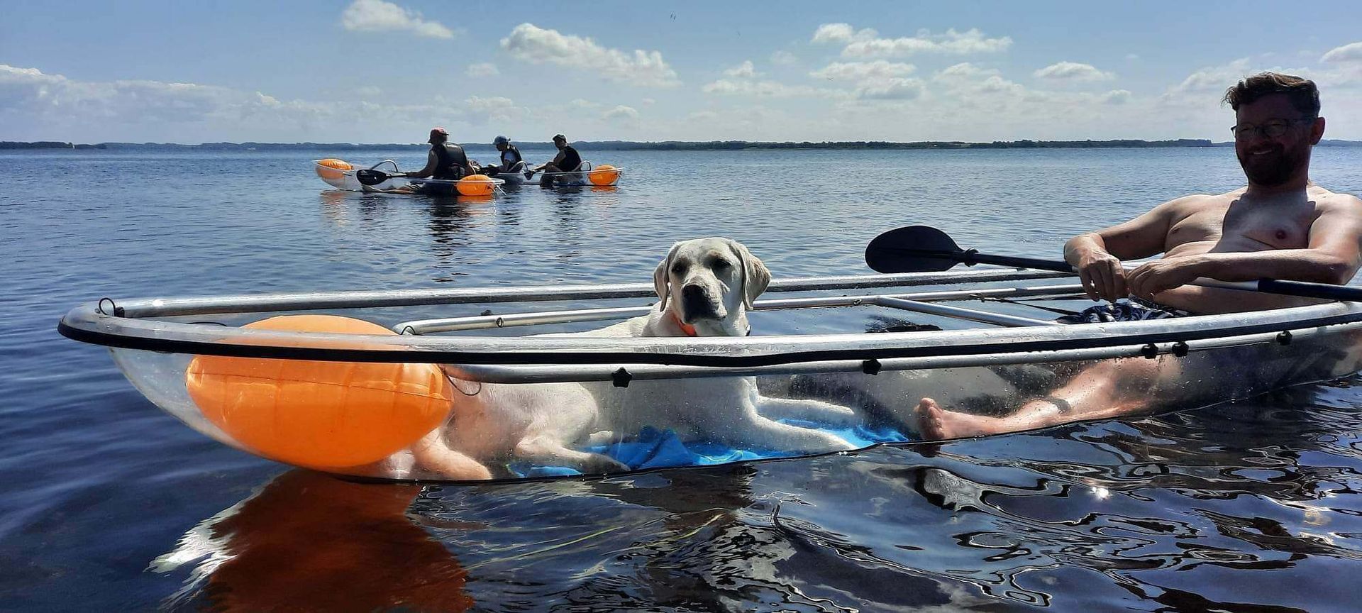 man met hond genieten in een transparante kajak op de loosdrechtse plassen