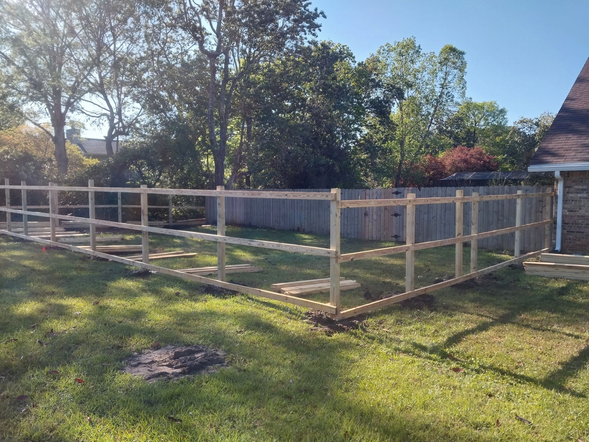 A Wooden Fence Is Being Built in The Backyard of A House — Crestview, FL — Coastal View Fencing LLC