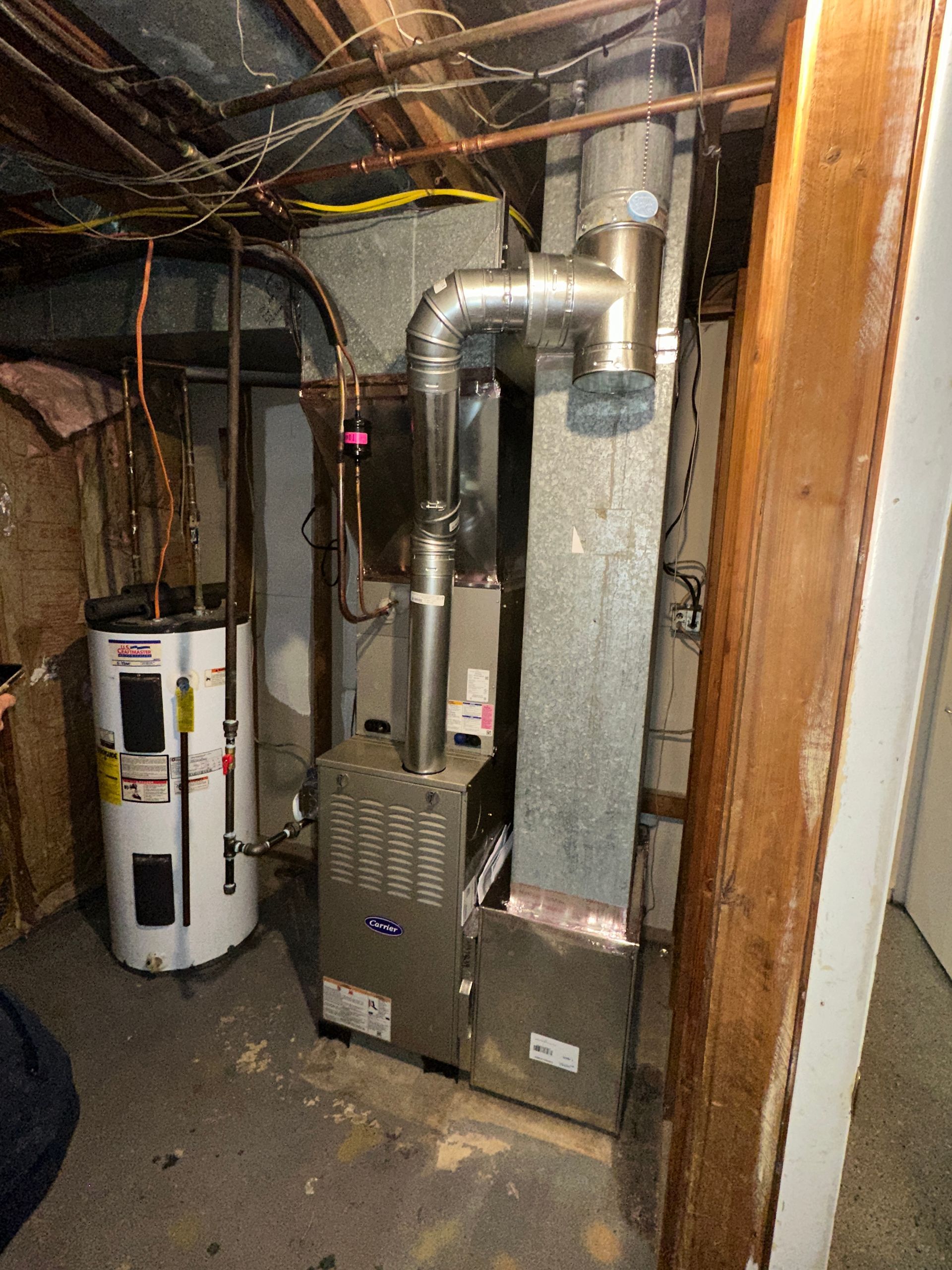 A furnace, water heater, and ductwork in a basement setting.