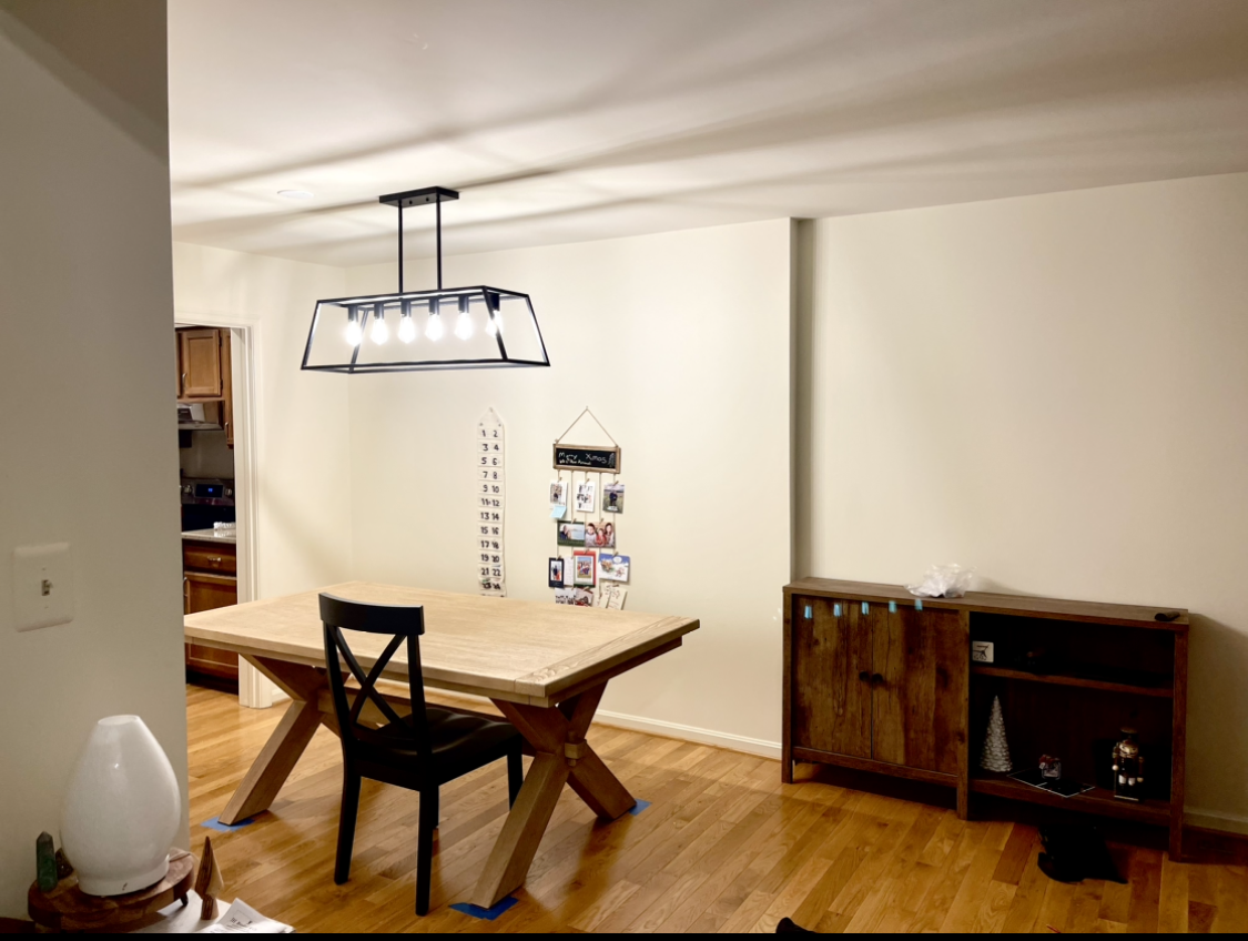 Dining room with wooden table, black chair, sideboard, and a rectangular light fixture.