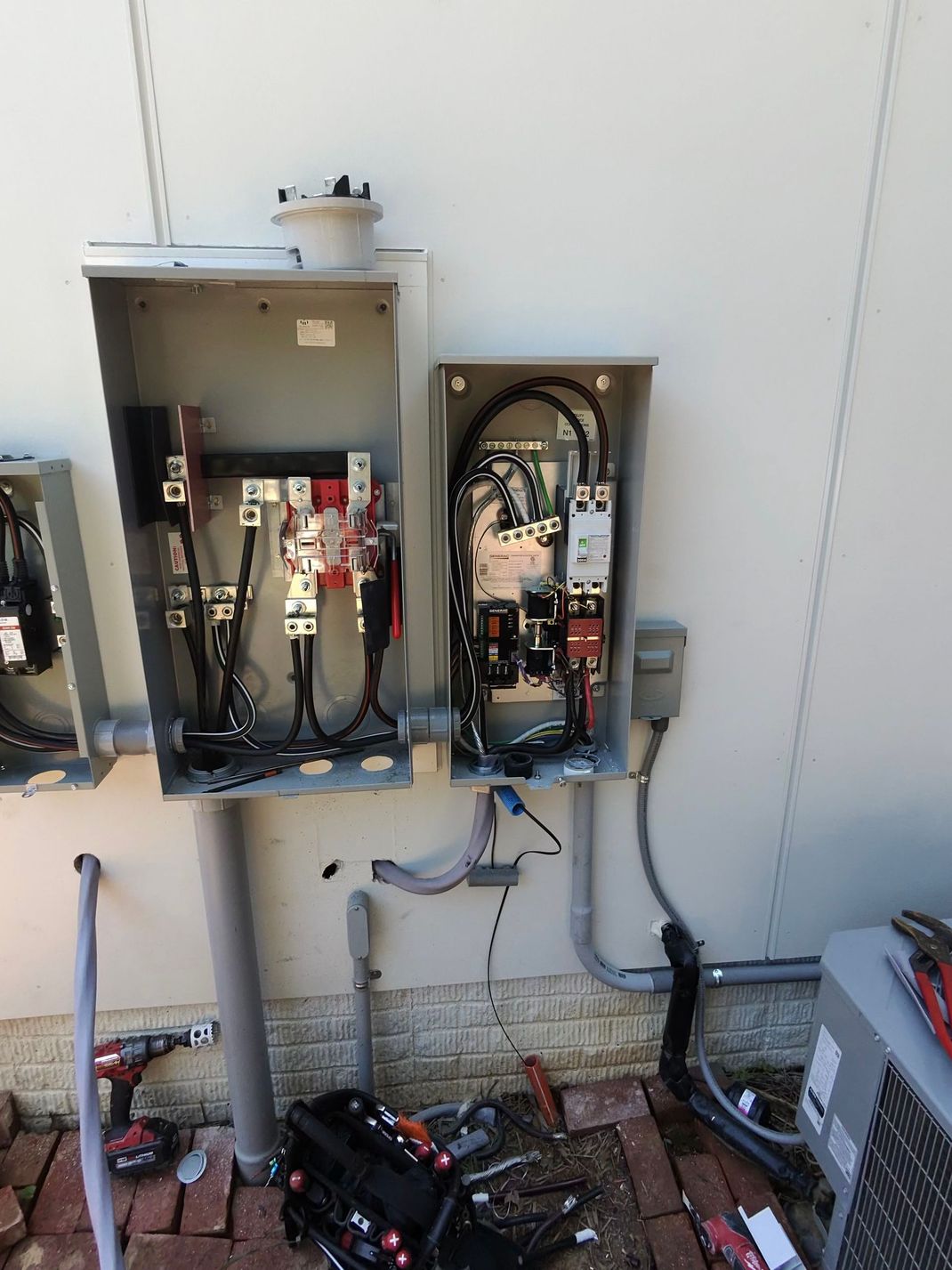 Electrical junction boxes mounted on a wall with wires and connections exposed. 