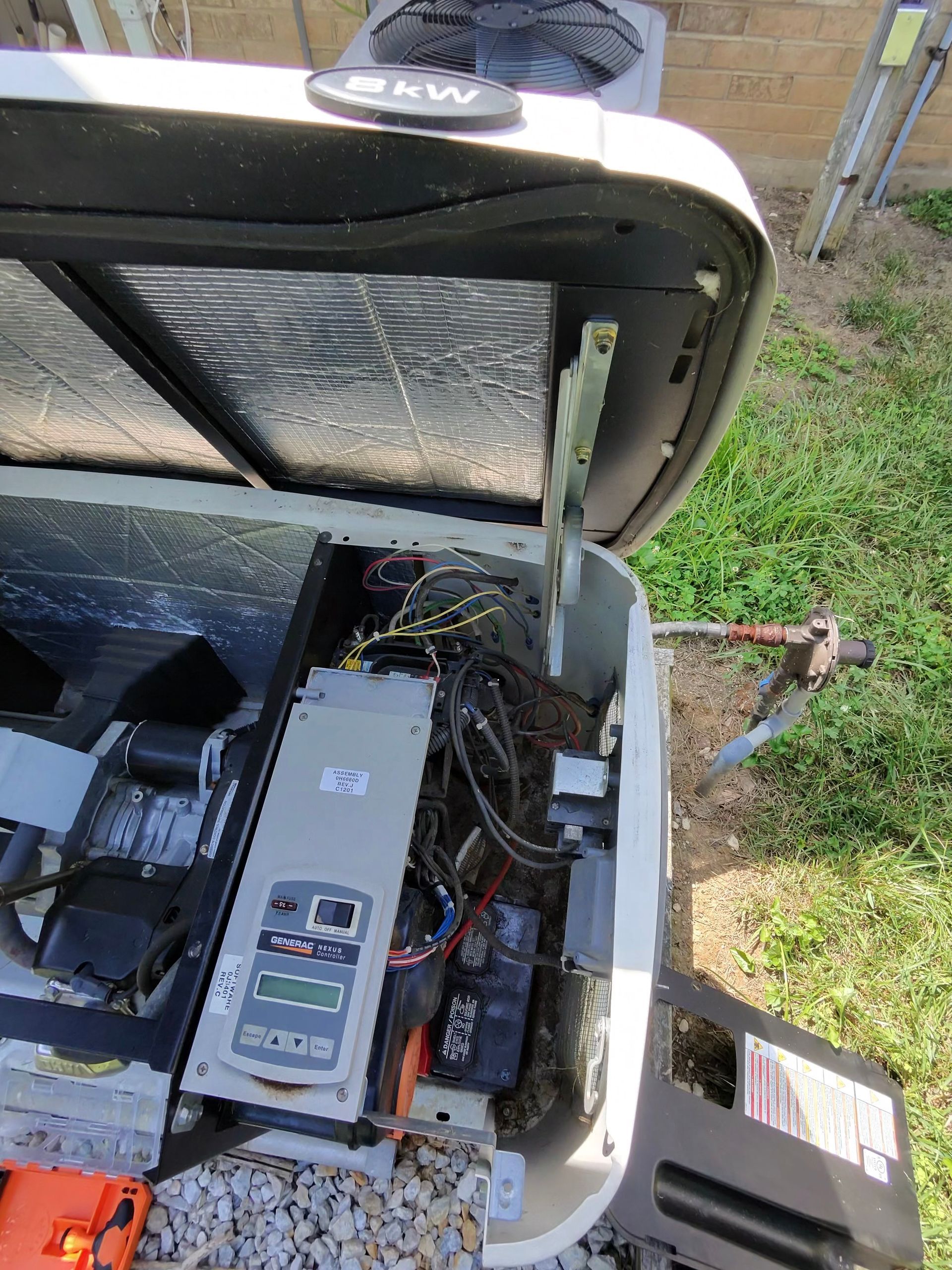 Generator with open access panel, revealing internal components and wiring.