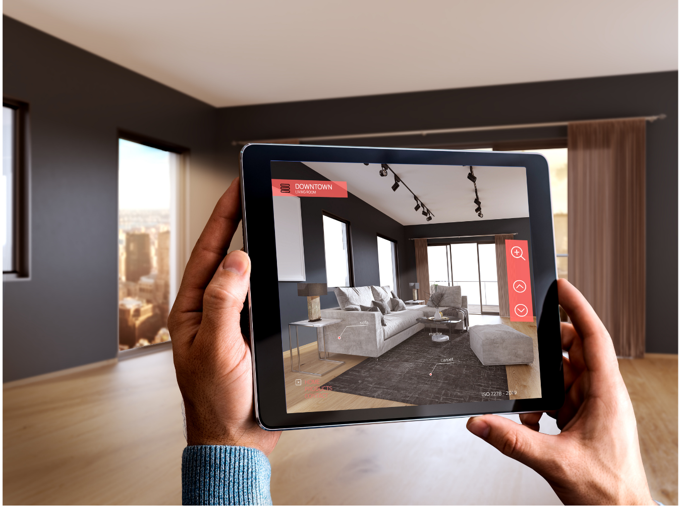A person is holding a tablet with a picture of a living room on it.