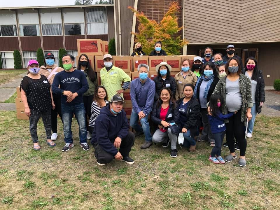 A group of people wearing masks are posing for a picture in front of a building.