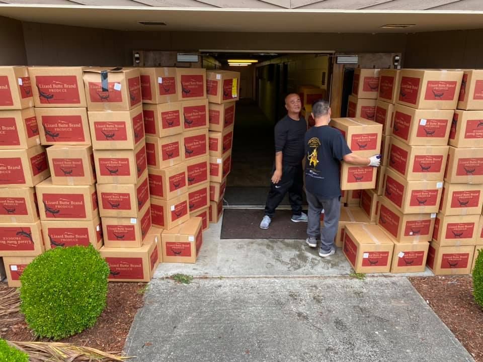 Two men are loading boxes into a building.