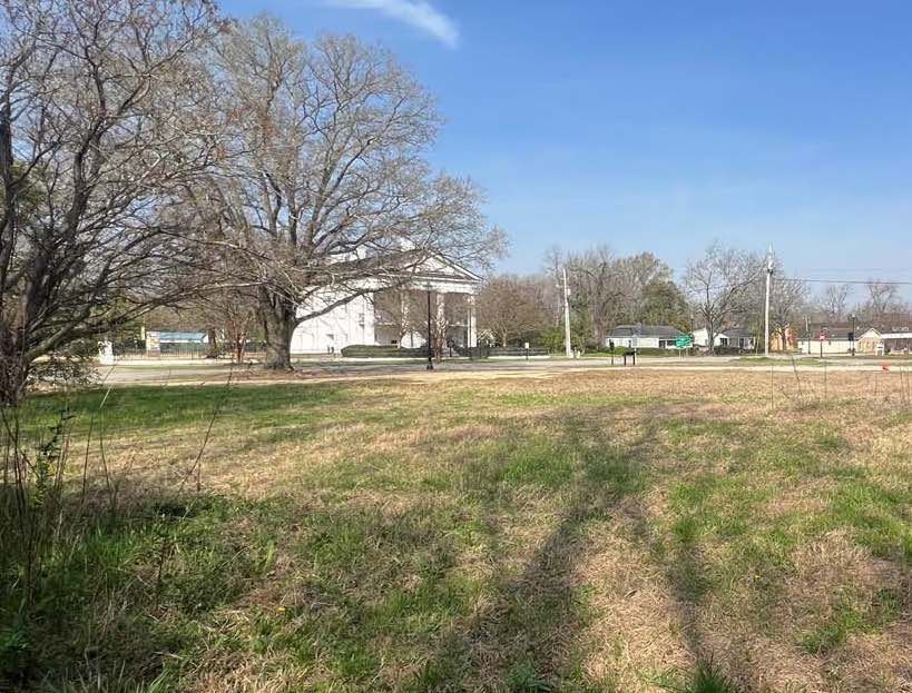 Camden Goal property—a large grassy field—Robert Mills Courthouse in the background .
