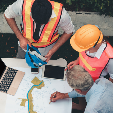 A group of construction workers are looking at a map