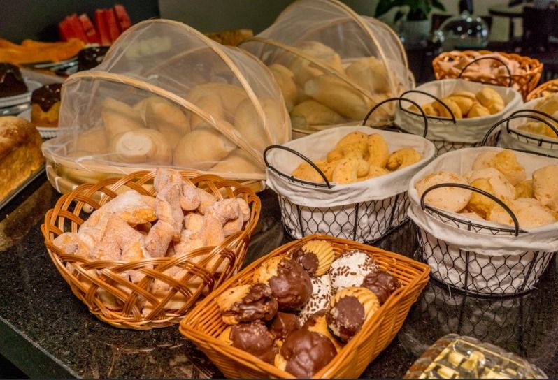 Uma mesa coberta com uma variedade de comidas, incluindo um bolo e frutas - MD Recanto Hotel