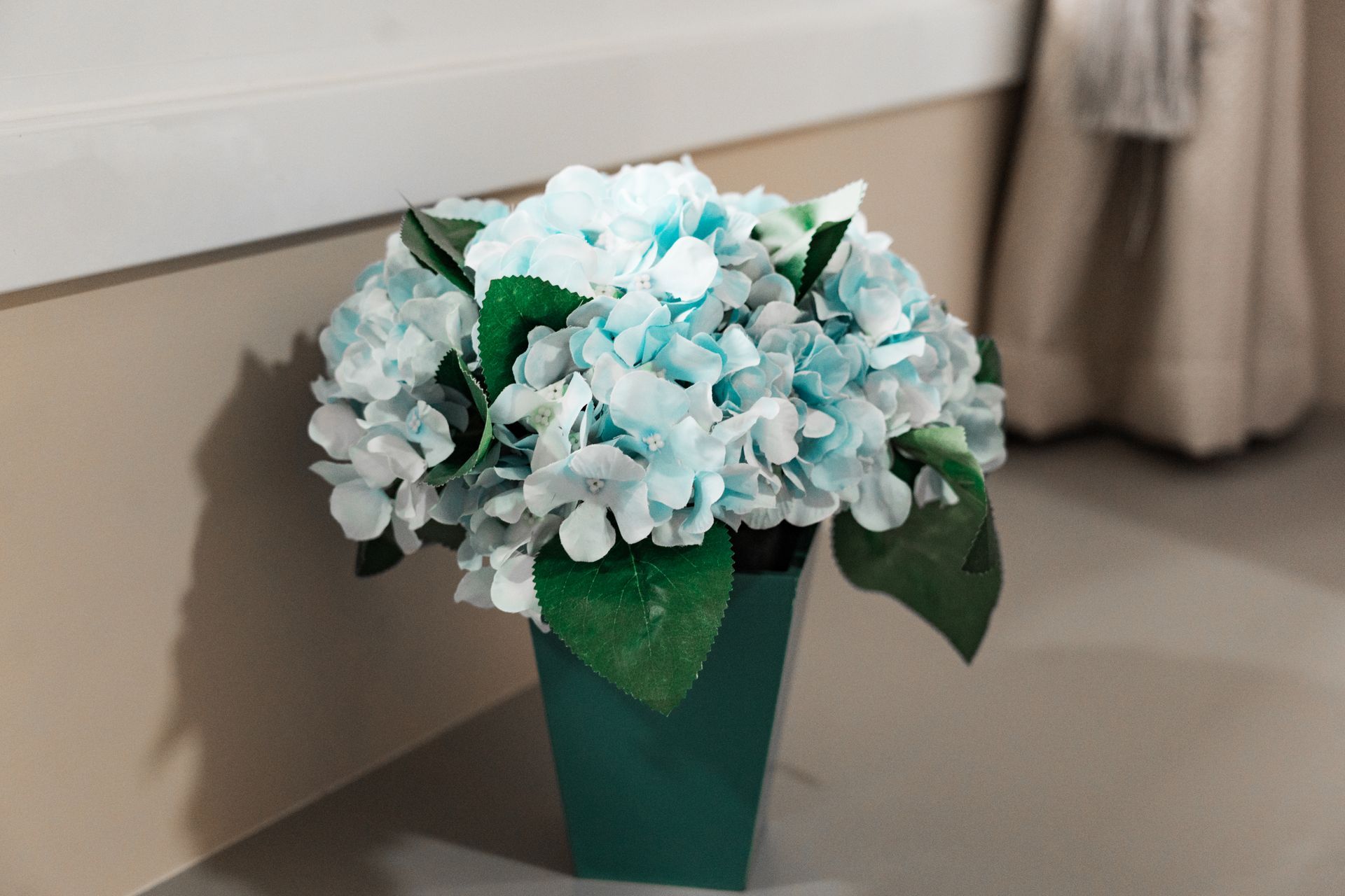 Um vaso cheio de flores azuis e brancas está sobre uma mesa. MD Recanto Hotel