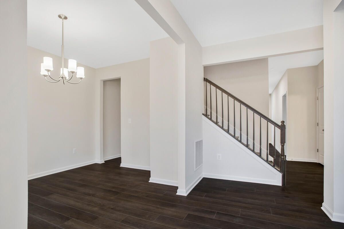 An empty room with a staircase and a chandelier
