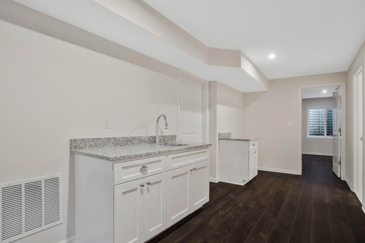 A kitchen with a sink , cabinets and hardwood floors
