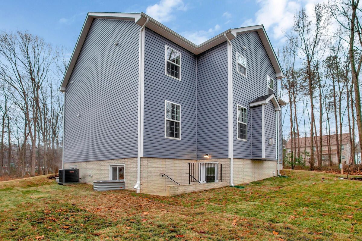 A large house with a lot of windows is sitting on top of a grassy hill.