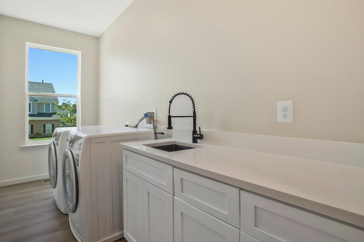 A laundry room with a washer and dryer and a sink.