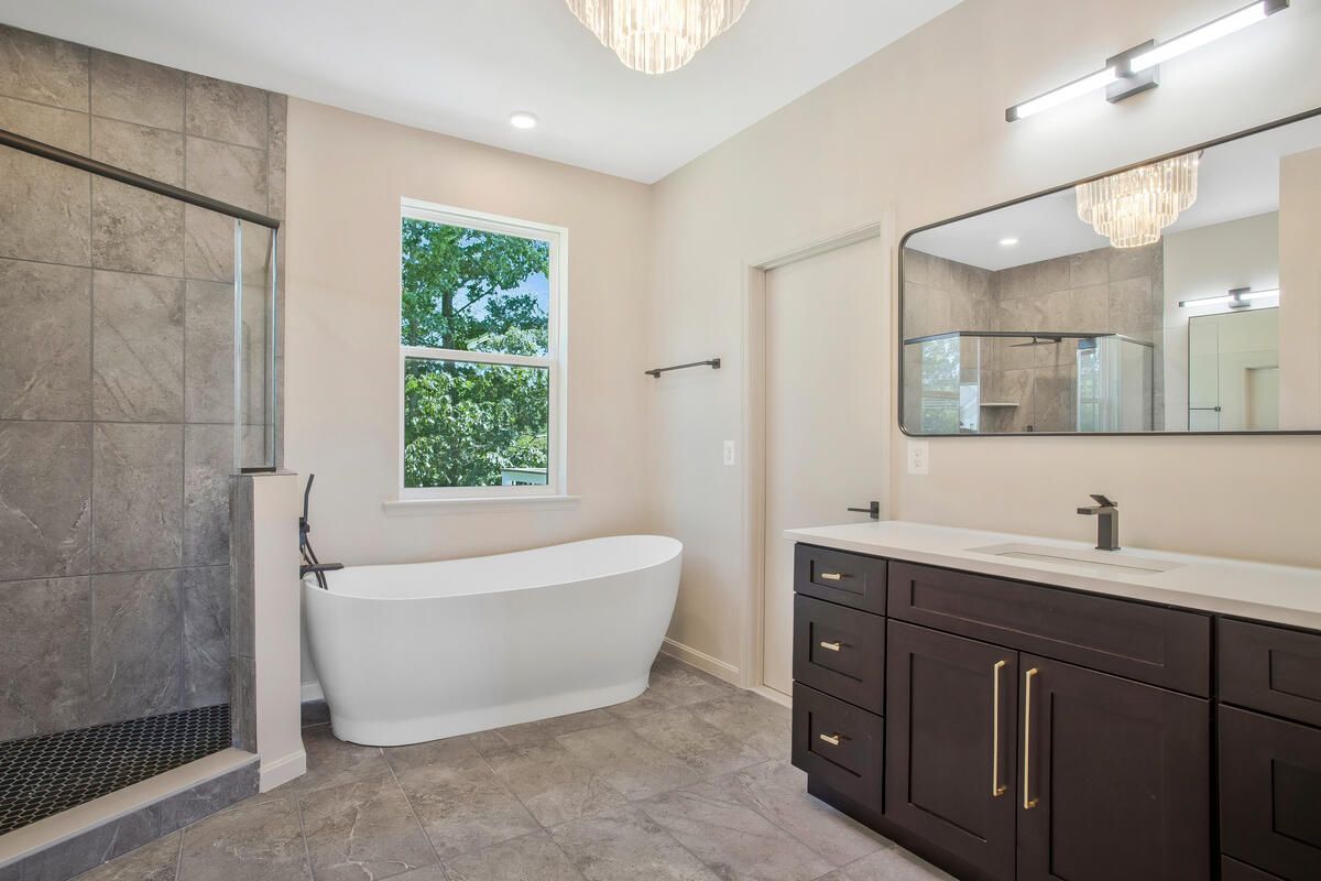 A bathroom with a tub , sink , and shower.