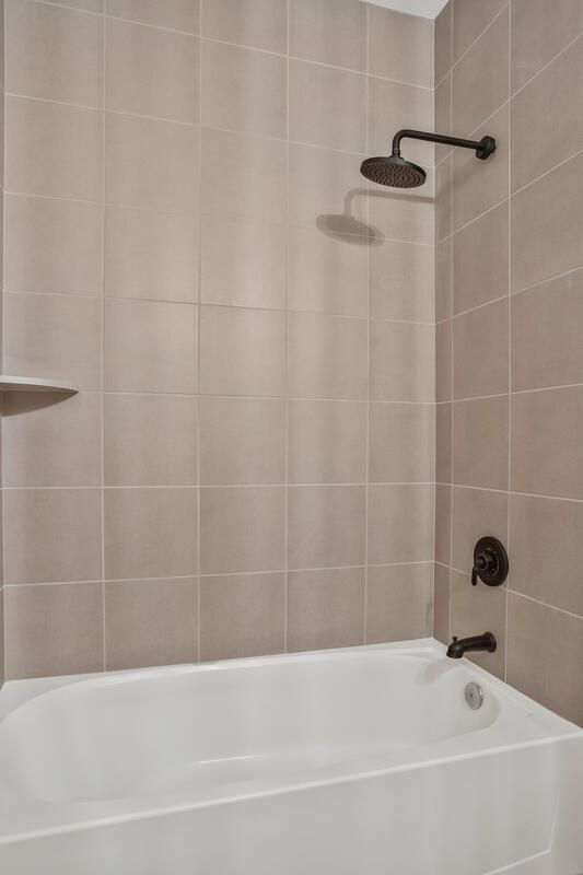 A bathroom with a bathtub and a shower head.