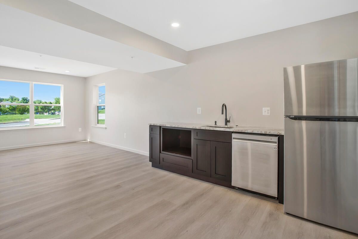 A kitchen with stainless steel appliances , a sink , and a refrigerator.