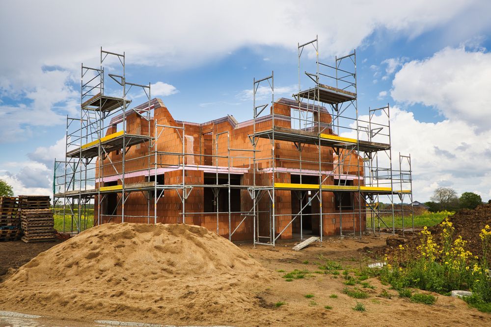 a brick house is being built with scaffolding around it .