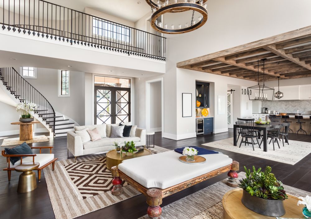 a living room filled with furniture and a staircase in a large house .