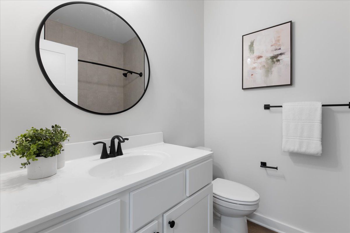 A bathroom with a sink , toilet and mirror