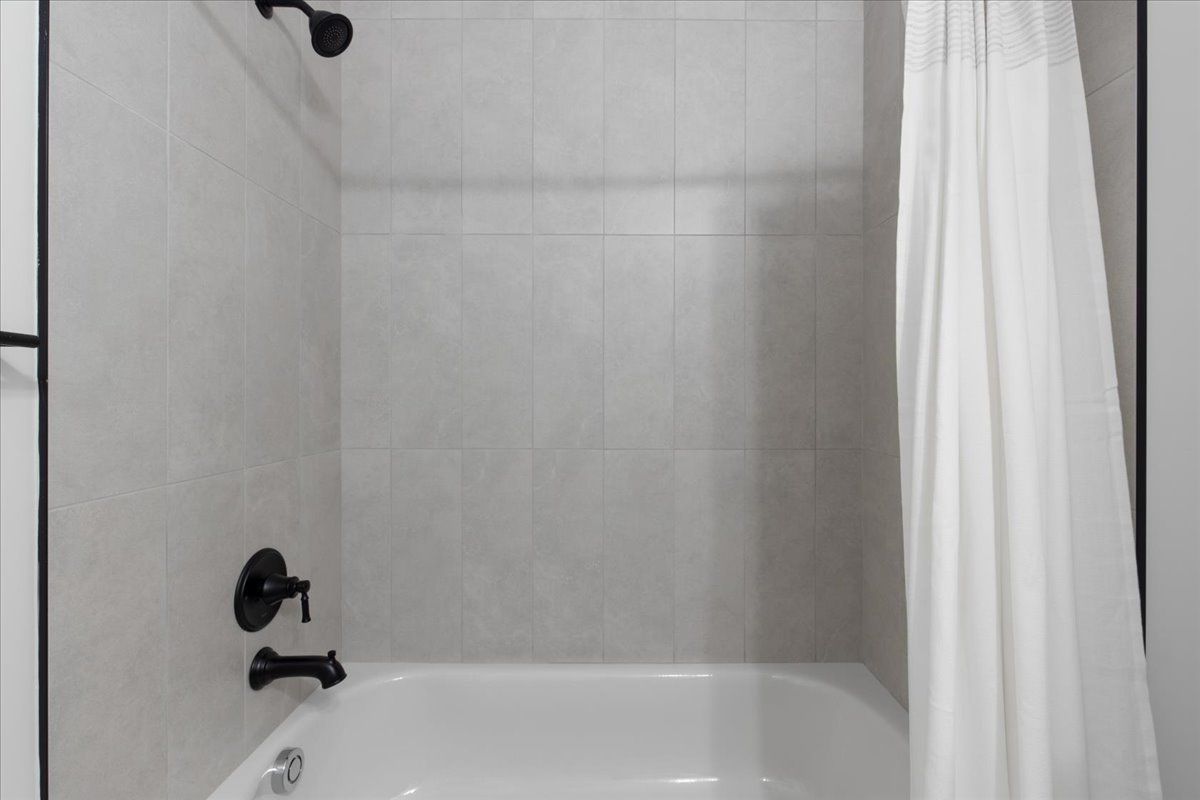A bathroom with a bathtub and a shower curtain.