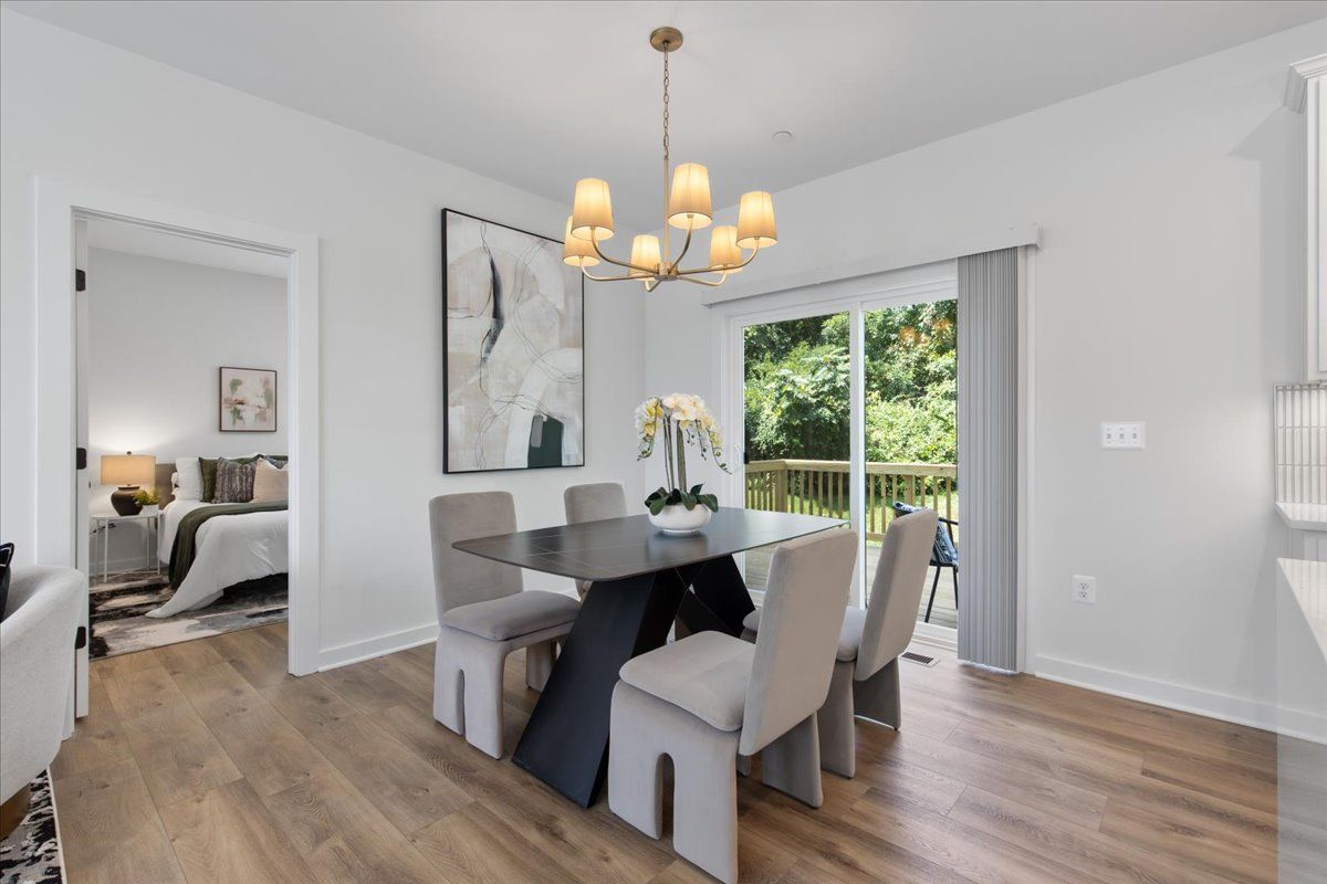 A dining room with a table and chairs and a chandelier.