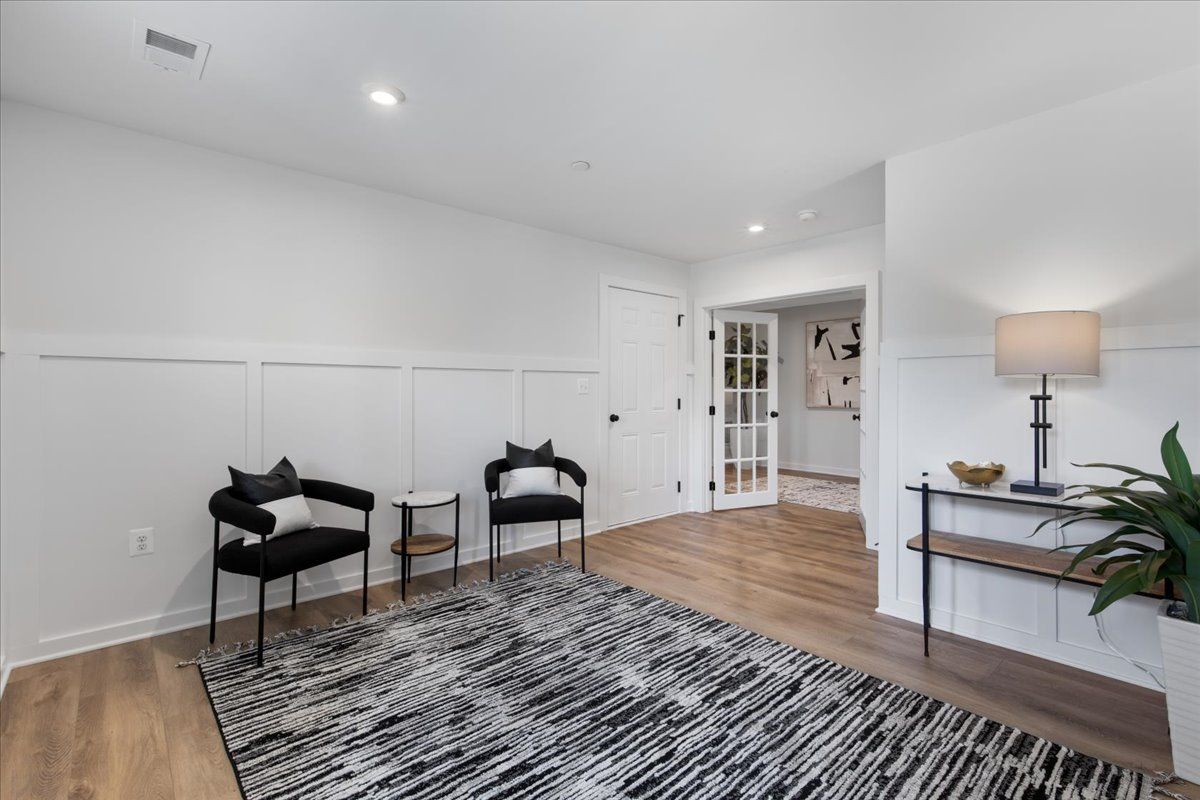 A living room with two chairs and a rug.