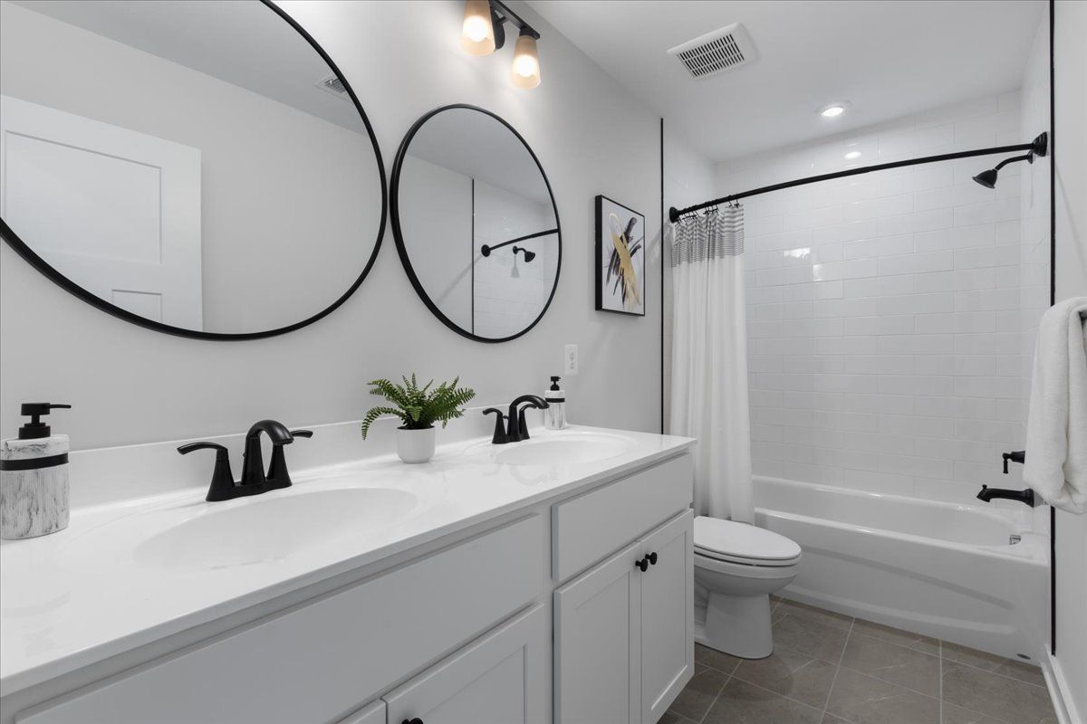A bathroom with two sinks , a toilet , and a bathtub.