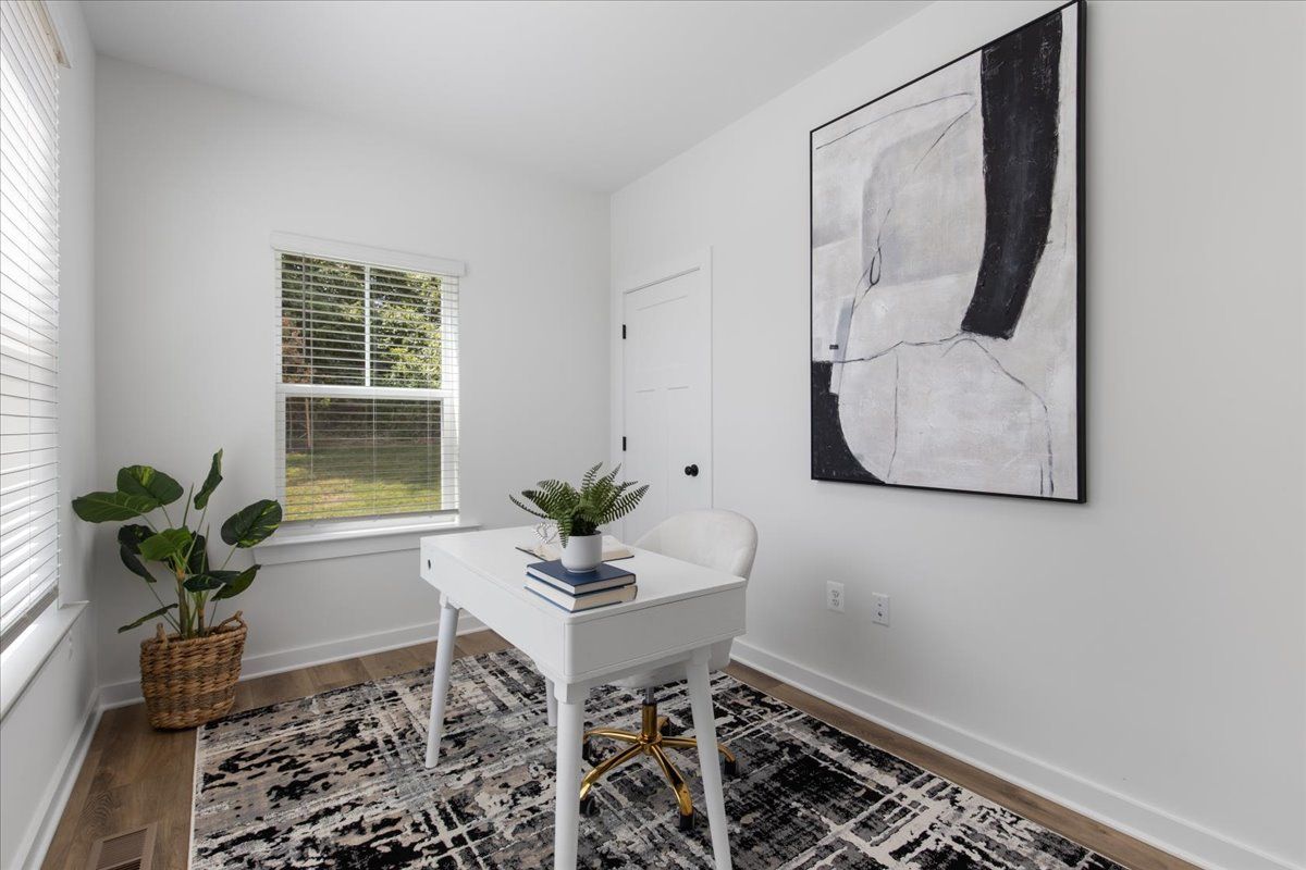 There is a painting on the wall above the desk in the room.