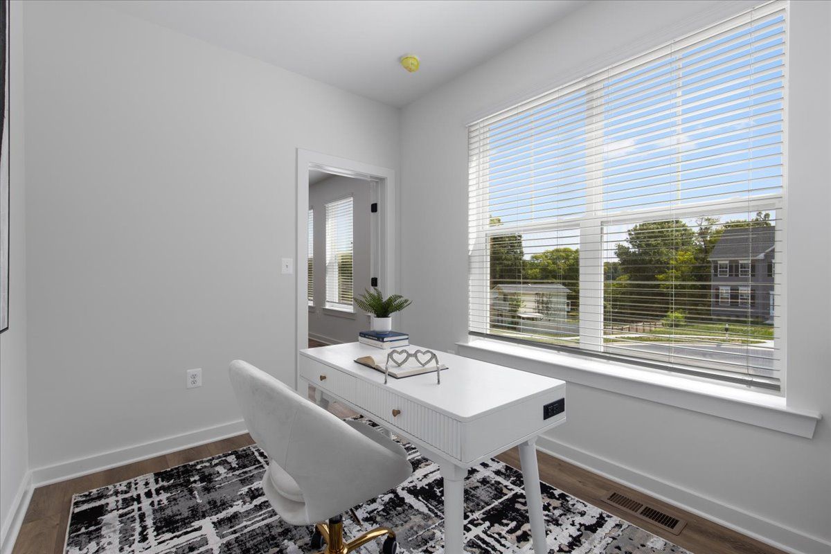 A home office with a desk and chair in front of a window.