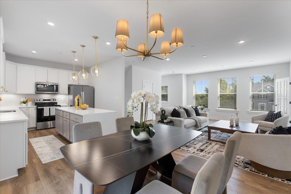 A dining room table with a vase of flowers on it in a living room.