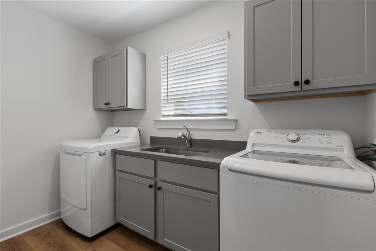 A laundry room with a washer and dryer and a sink.